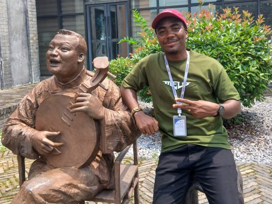 In_Conversation_with_Ebenezer_Doto_Kukai_on_turning_a_grassroots_innovation_into_agricultural_leadership_6 Ebenezer Kukai posing for a picture with a statue. Photo courtesy: Ebenezer Kukai